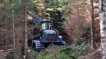 A forest harvesting machine working among trees in Evo, Finland.