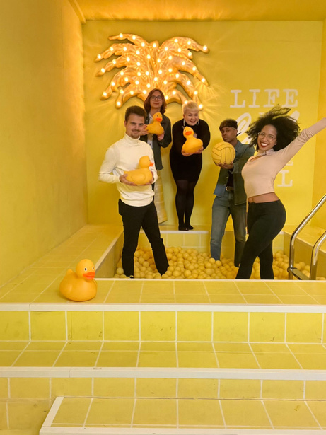 Student in yellow room with yellow plastic ducks and balls.