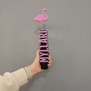 Vaaleanpunainen ja musta oluthanka, jossa lukee Mylläri. Flamingo koristeena hanan päässä.