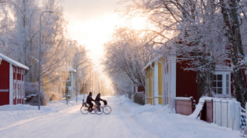 Kaksi pyöräilijää lumisessa Hämeenlinnassa