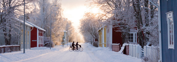 Kaksi pyöräilijää lumisessa Hämeenlinnassa