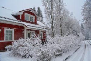 Punainen talo talvella kuvattuna tieltä.