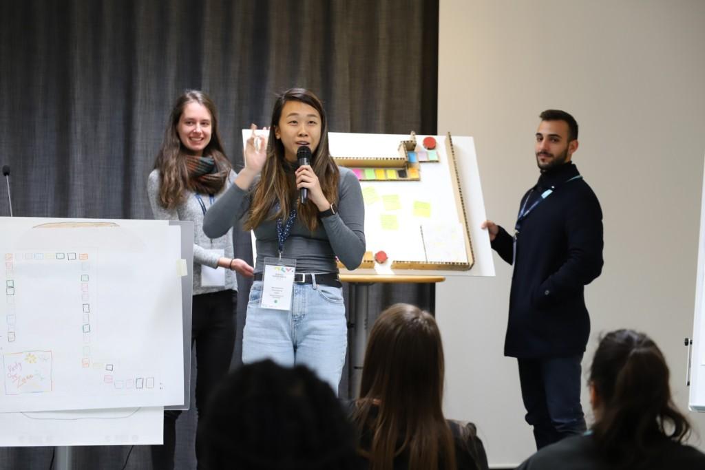 Three students giving a presentation on stage