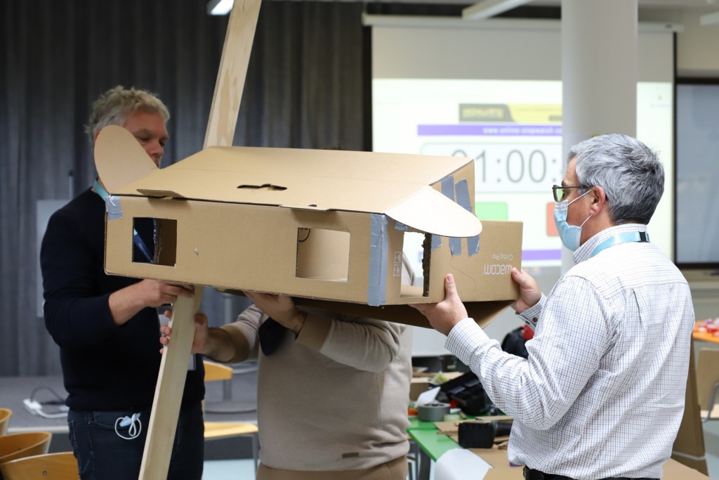 Three men building a machine out of carbon