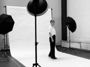 Black and white picture of a model being photographed.